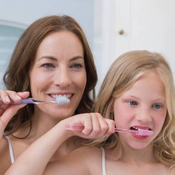 Mother and daughter brushing teeth together