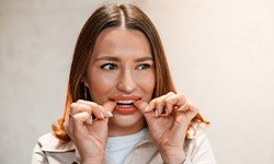 Patient putting on clear aligner in treatment room