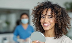 Woman smiling while holding small mirror