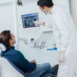 Dentist showing dental x-rays to male patient