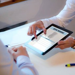 Patient and team member looking at insurance forms on tablet computer
