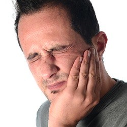 Man holding jaw in pain