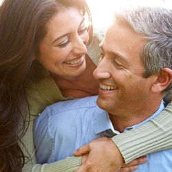 An older man and woman hugging and smiling