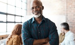 a smiling man with his arms crossed