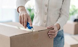 Person using a boxcutter to open a package