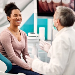 Smiling patient learning about the cost of Six Month Smiles