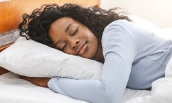 Woman sleeping peacefully with help of Vivos oral appliances