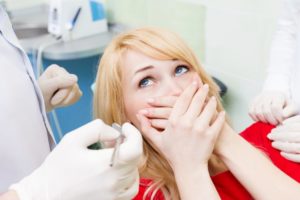 Worried woman covers her mouth while visiting her Greenfield dentist