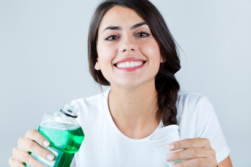 Woman smiling with mouthwash before dental appointment
