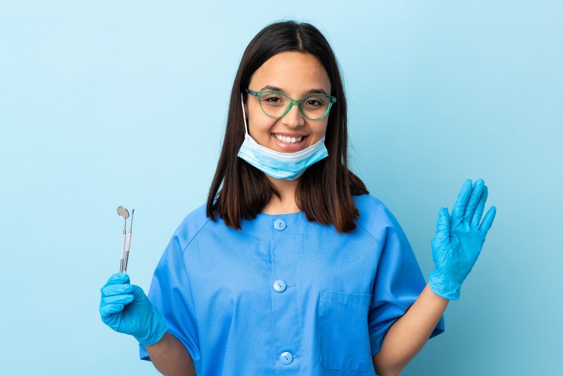 Dentist wearing PPE and waving