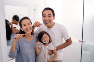 parents brushing their teeth with their child