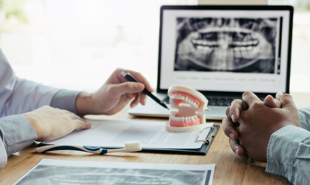 A dentist showing a patient a model of the mouth